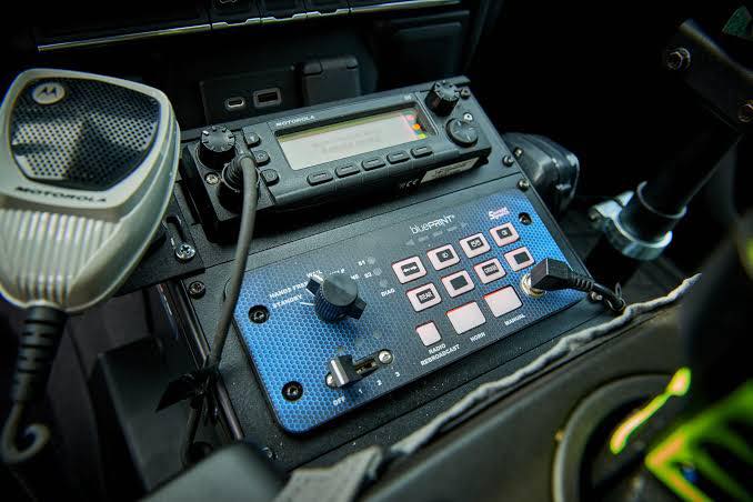 Police vehicle center console with siren controller, switch panel, and laptop mount